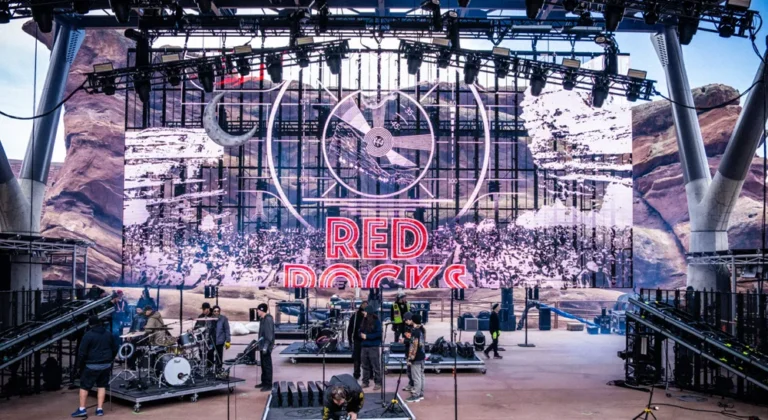 Alquilar equipos audiovisuales: qué comprobar antes de firmar el albarán 5 Escenario en fase de montaje con pantalla LED, rig de iluminación y equipo técnico preparando el material audiovisual