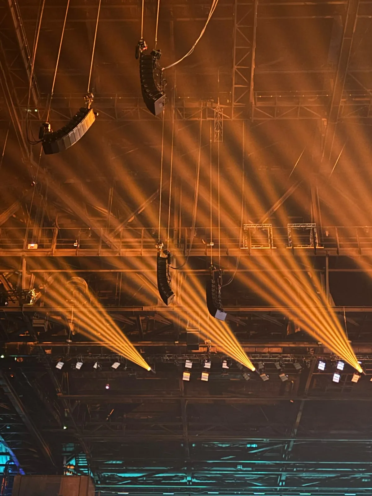 d&b Soundscape en La Défense Arena: el sonido espacializado del espectáculo de Artus 3 Detalle de varios arrays de altavoces d&b audiotechnik colgados de la estructura de La Défense Arena entre haces de luz
