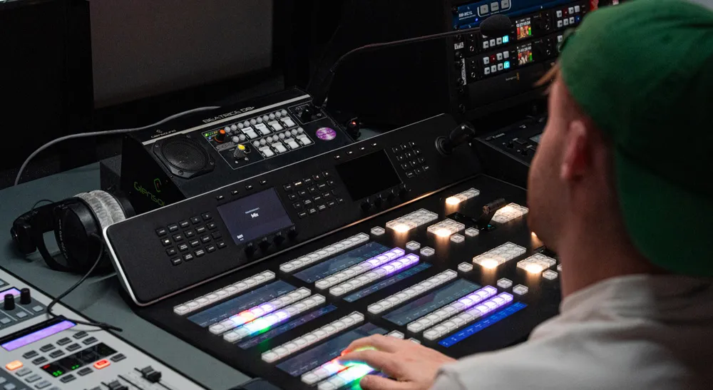 The United Stand lleva su producción en directo a un estudio permanente con ATEM Constellation 8K 4 Primer plano del panel ATEM 2 M/E Advanced Panel 20 mientras un realizador conmuta fuentes en el control del estudio.