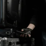 Técnico acercando un teléfono móvil a la base de una cabeza móvil Cameo apoyada sobre un flight case para transferirle la configuración por NFC