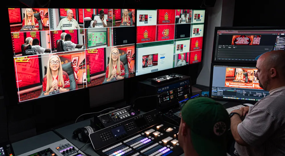 The United Stand lleva su producción en directo a un estudio permanente con ATEM Constellation 8K 3 Control de realización de The United Stand con el multiviewer del mezclador ATEM Constellation 8K y dos técnicos operando durante una emisión en directo.