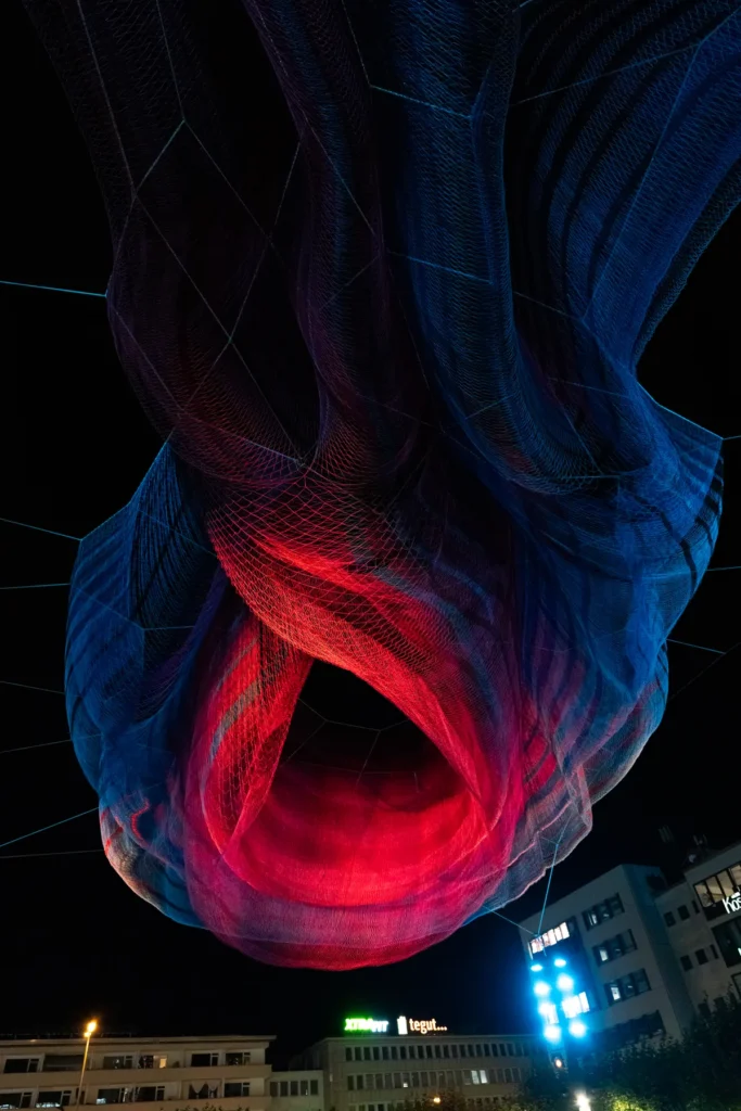 Degradado de azul a rojo sobre la superficie de red de la escultura de Janet Echelman