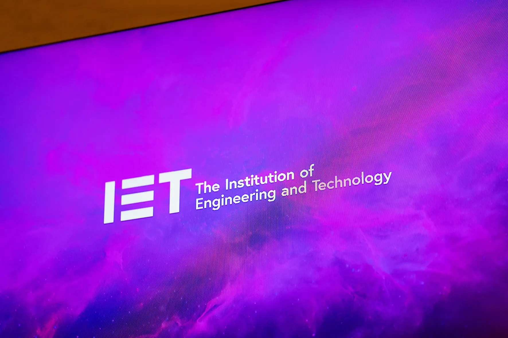 IET Savoy Place cambia la doble proyección por una pantalla LED 4K de Leyard preparada para broadcast 2 Detalle en primer plano de la superficie LED DirectLight Pro mostrando el logotipo del IET sobre un fondo púrpura
