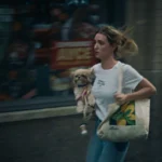 Anne corre por una calle de Nueva York con la perra Macy en la bolsa, en un plano del cortometraje The Actor etalonado con DaVinci Resolve Studio.
