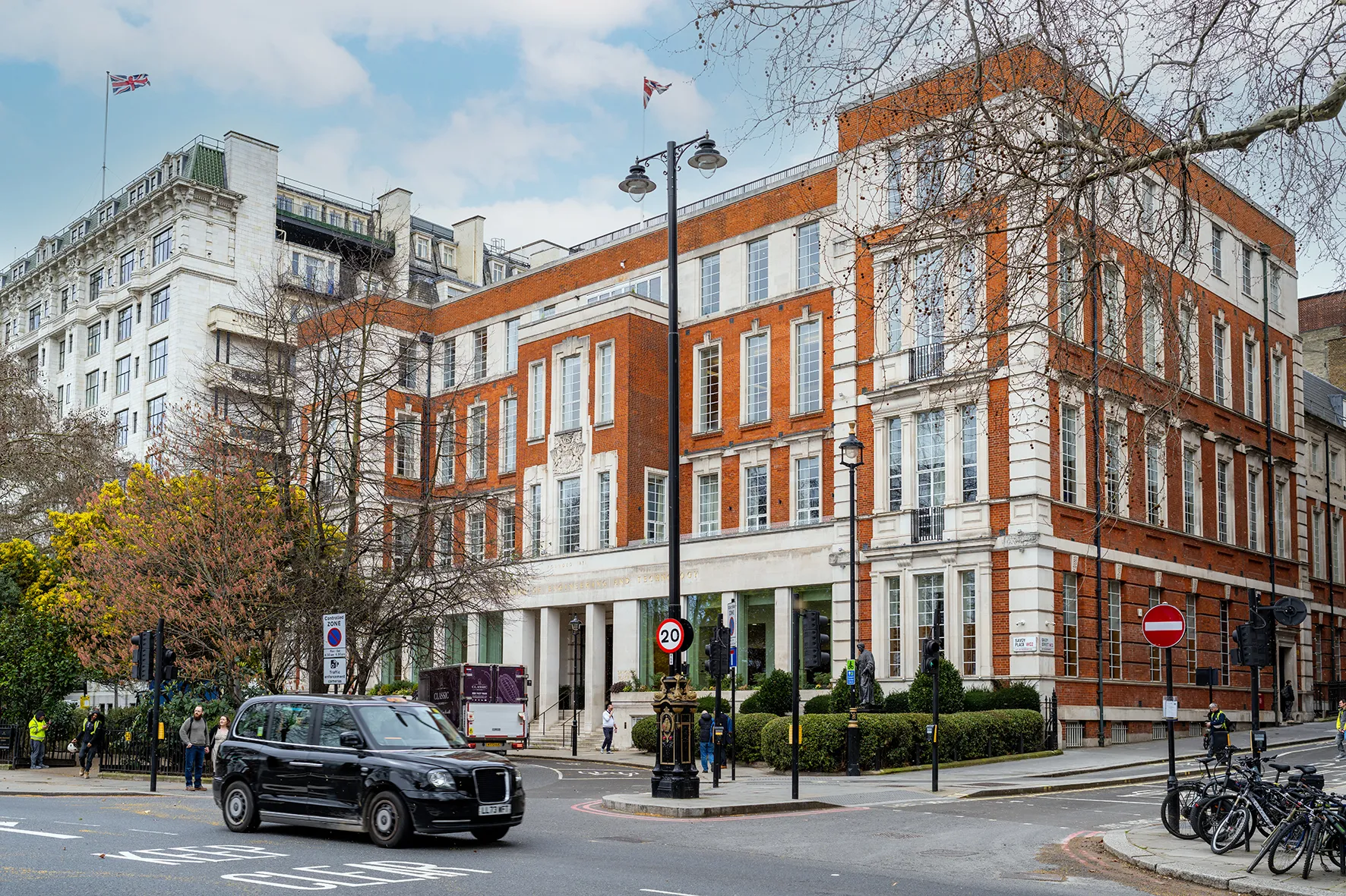 IET Savoy Place cambia la doble proyección por una pantalla LED 4K de Leyard preparada para broadcast 3 Fachada de ladrillo y piedra del edificio IET Savoy Place en una esquina de Londres, con un taxi negro circulando por la calle