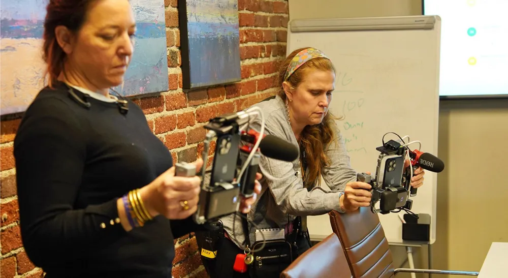 «Legal Queens»: 80 episodios de producción vertical con Blackmagic Camera y equipo mínimo 2 Dos operadoras del equipo de «Legal Queens» sujetan sendos iPhone montados en armazones con micrófono de cañón dentro de las oficinas del bufete
