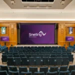 Auditorio Kelvin Lecture Theatre del IET Savoy Place con la pantalla LED DirectLight Pro instalada sobre el escenario, entre paneles de madera y butacas azules