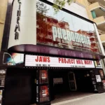 Fachada del cine Phenomena Experience en Barcelona con la marquesina iluminada y la programación del día