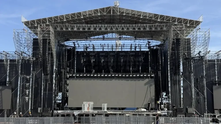 Escenario de exterior en fase de montaje, con el sistema de PA volado, pantalla LED y parrilla de iluminación sobre estructura de truss