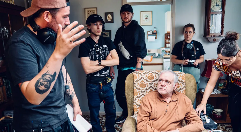 Deadheading, la comedia negra en gran formato premiada en los Sony Future Filmmaker Awards 3 El equipo de rodaje prepara un plano de interior alrededor de un actor sentado en un sillón