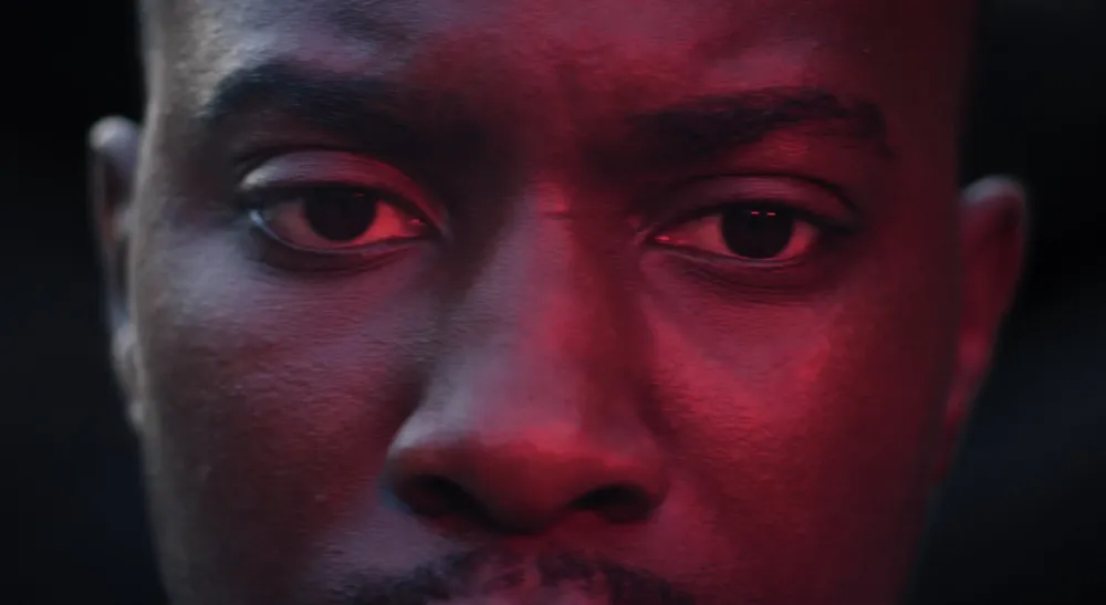 Primer plano de un personaje con etalonaje en tonos rojos intensos durante la posproducción de Moral Dirt en DaVinci Resolve Studio