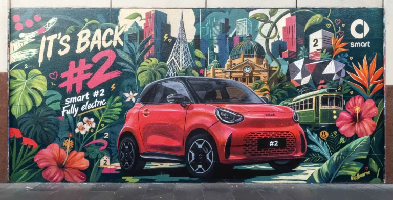 El smart #2 incorporará un sistema de sonido Sennheiser de siete altavoces 4 Mural callejero con un smart #2 rojo de perfil y el lema «It’s back», junto al logotipo de smart