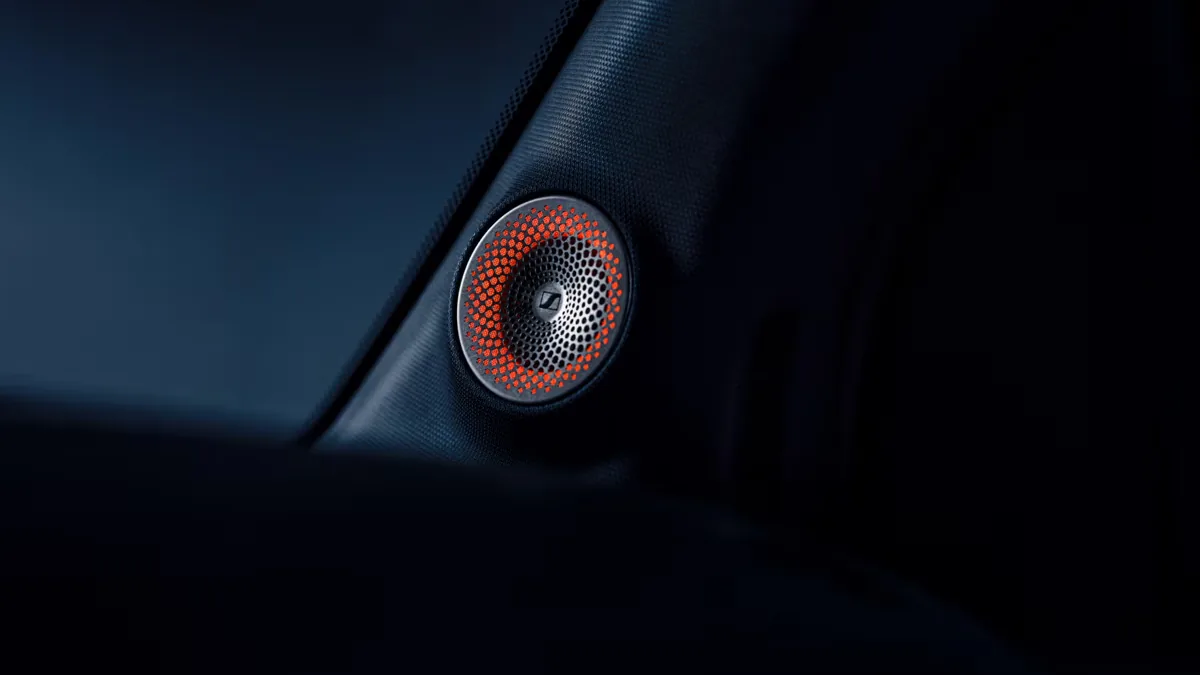 El smart #2 incorporará un sistema de sonido Sennheiser de siete altavoces 2 Altavoz Sennheiser con rejilla perforada naranja integrado en el interior oscuro de un vehículo
