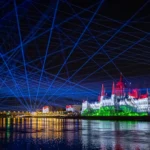 Proyección sobre el Parlamento de Hungría con los colores de la bandera húngara y haces láser azules sobre el Danubio durante el Día de San Esteban en Budapest