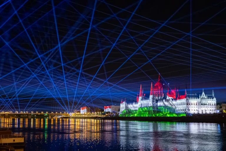 Proyección sobre el Parlamento de Hungría con los colores de la bandera húngara y haces láser azules sobre el Danubio durante el Día de San Esteban en Budapest