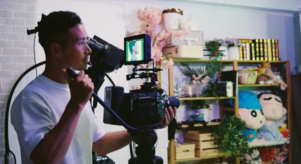 Vultures rueda su microdrama vertical con Blackmagic URSA Mini Pro entre Rumanía y Taiwán 4 Operador de cámara sujeta a hombro una cámara Blackmagic con monitor externo durante el rodaje de la serie vertical «Vultures»