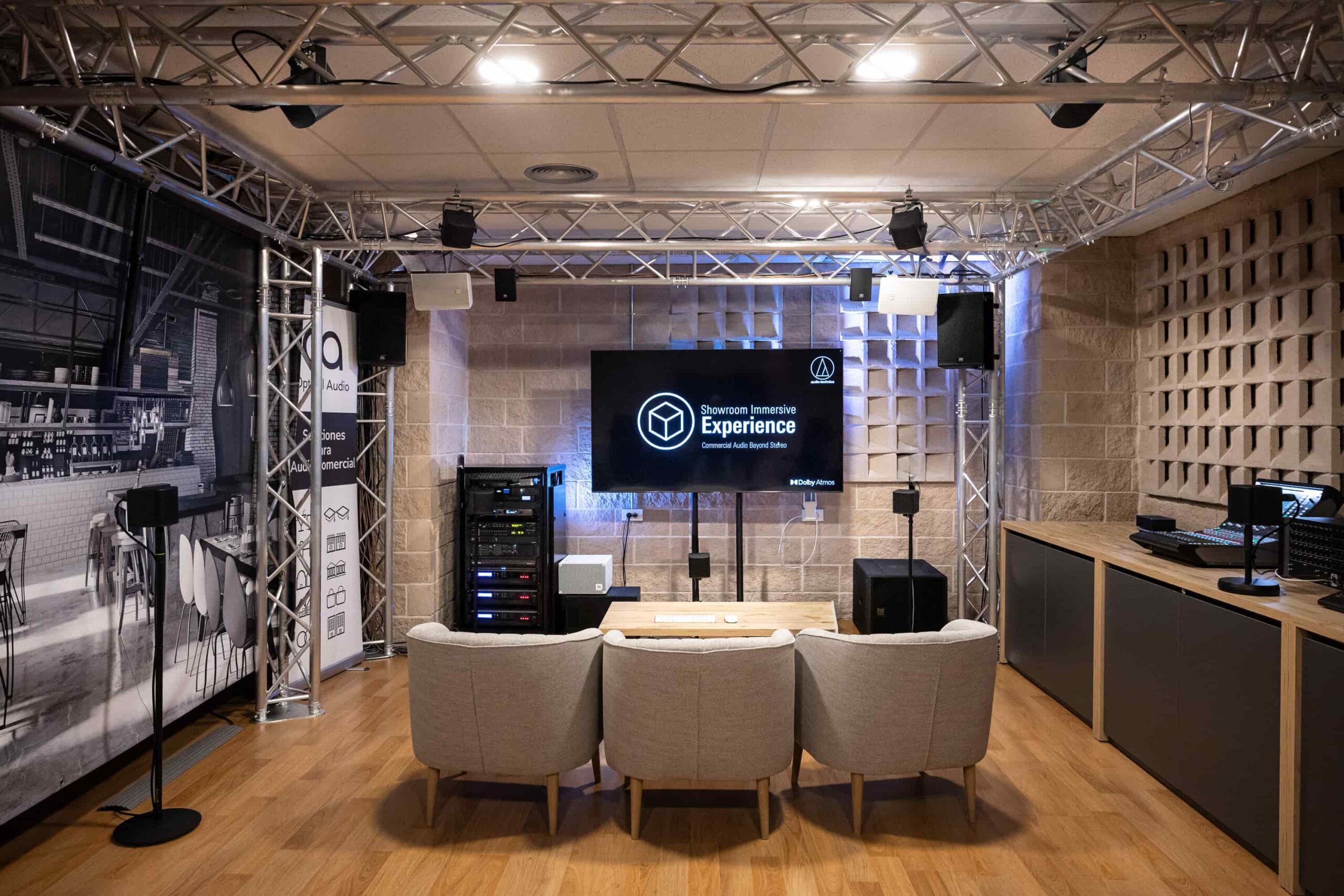 Audio en red para instalaciones profesionales: cómo diseñar sistemas Dante/IP escalables y fáciles de gestionar 11 Showroom de audio inmersivo Audio-Technica con altavoces, rack de equipos y sistemas audiovisuales para demostraciones profesionales.