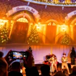 Escenografía navideña proyectada en el interior de la cúpula de ApolloDomes en Gunwharf Quays, con actores en directo y público