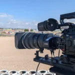 Cámara Blackmagic URSA Broadcast G2 con óptica broadcast junto a una barrera de neumáticos, orientada hacia la pista de un circuito