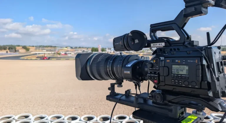 Cámara Blackmagic URSA Broadcast G2 con óptica broadcast junto a una barrera de neumáticos, orientada hacia la pista de un circuito
