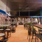 Zona exterior cubierta del Dakabin Hotel, en Queensland, con altavoces de superficie en la pared de ladrillo